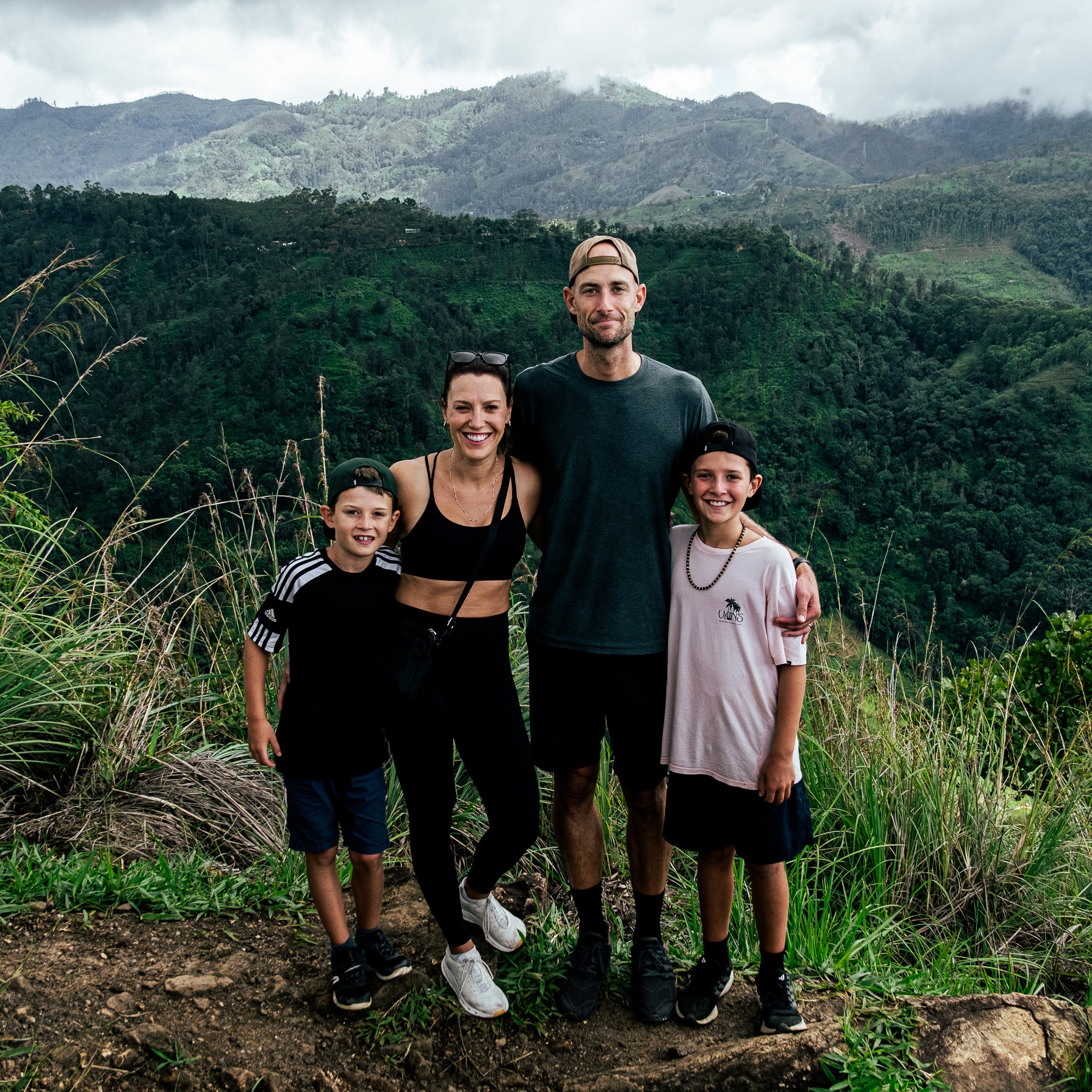 Claudia et Maxime, fondateurs de Grounded, en randonnée avec leurs enfants dans un paysage de montagne. Une famille engagée derrière une alimentation végétale durable et locale.