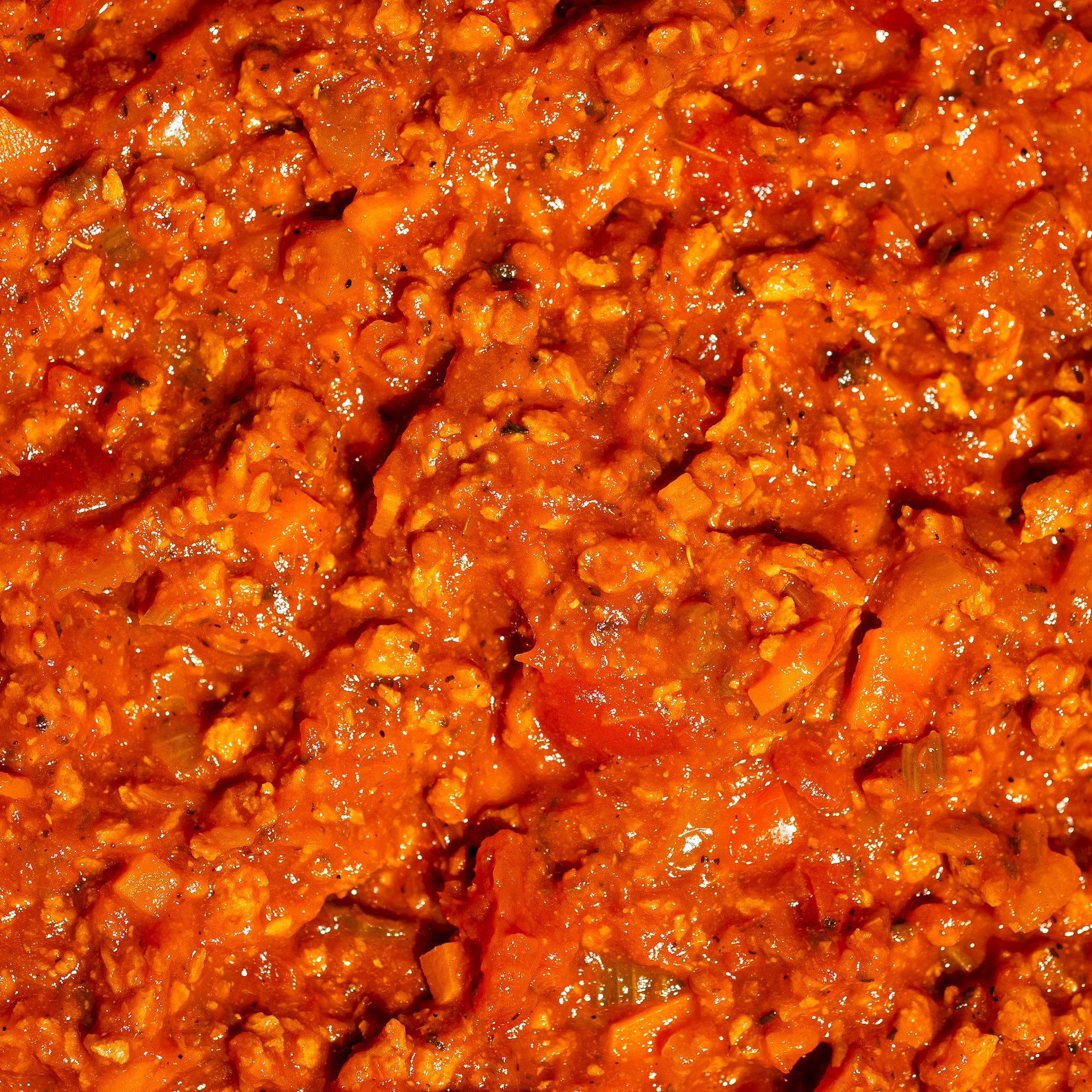 Gros plan sur la sauce bolognaise végétalienne Grounded, riche et texturée, préparée avec des tomates, des légumes et la protéine végétale texturée à base de pois jaunes. Une alternative sans viande, savoureuse et protéinée.