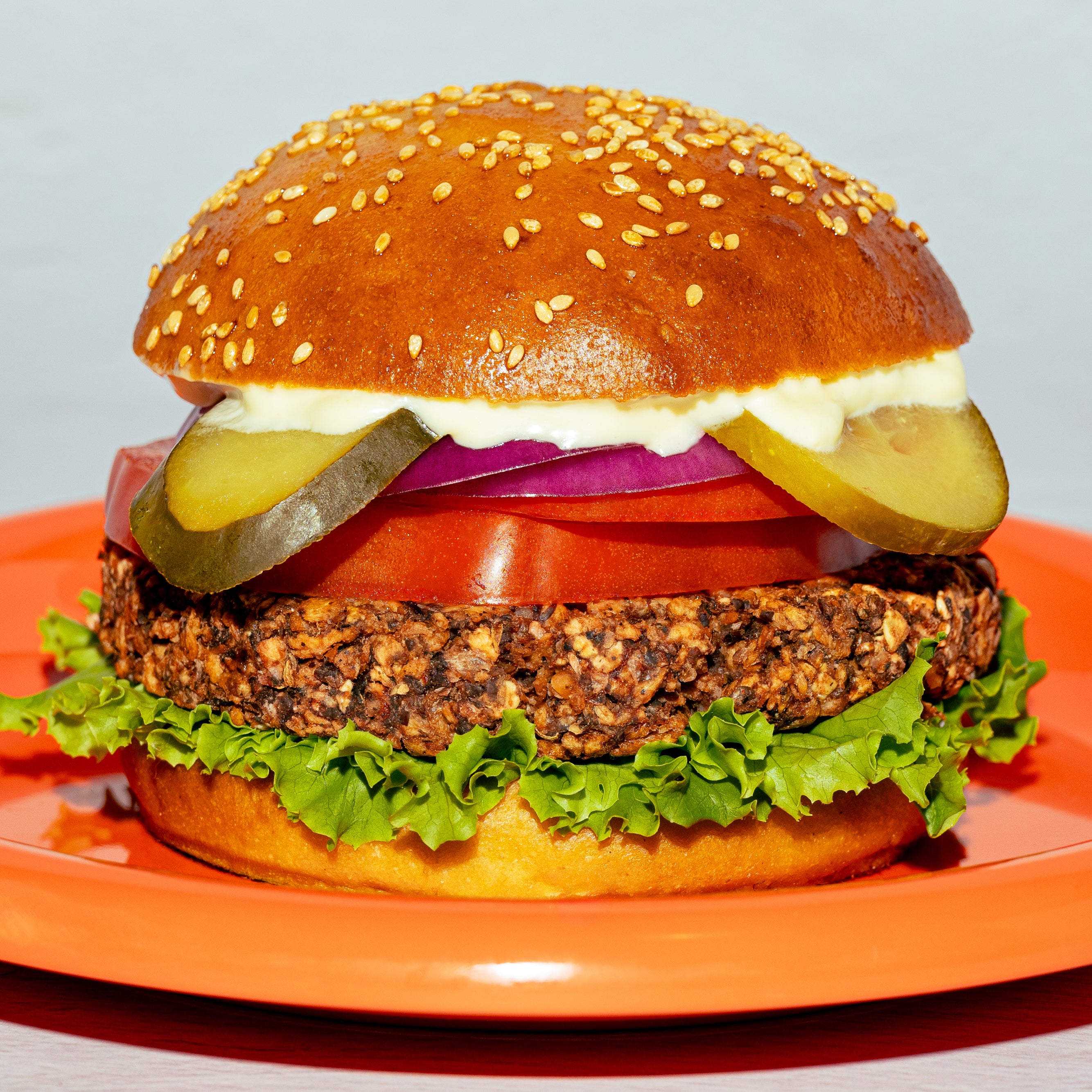 Burger végé créé avec Loounie, garni d’une galette de PVT à base de protéines de pois, laitue, tomate, cornichons, oignon rouge et sauce.