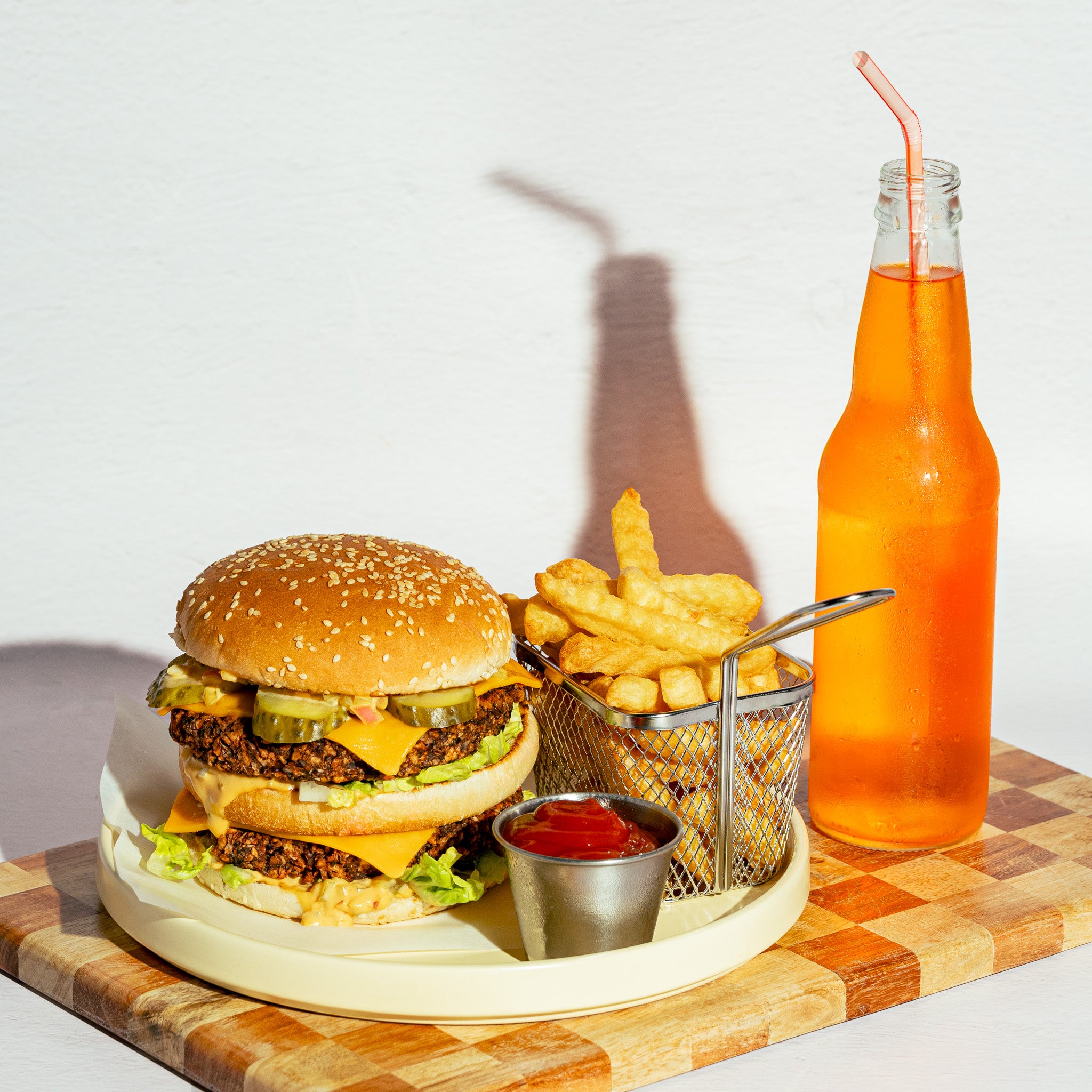 Combo burger végé créé avec Loounie, préparé avec deux galettes de PVT à base de protéines végétales, servi avec frites, sauce et boisson orange.