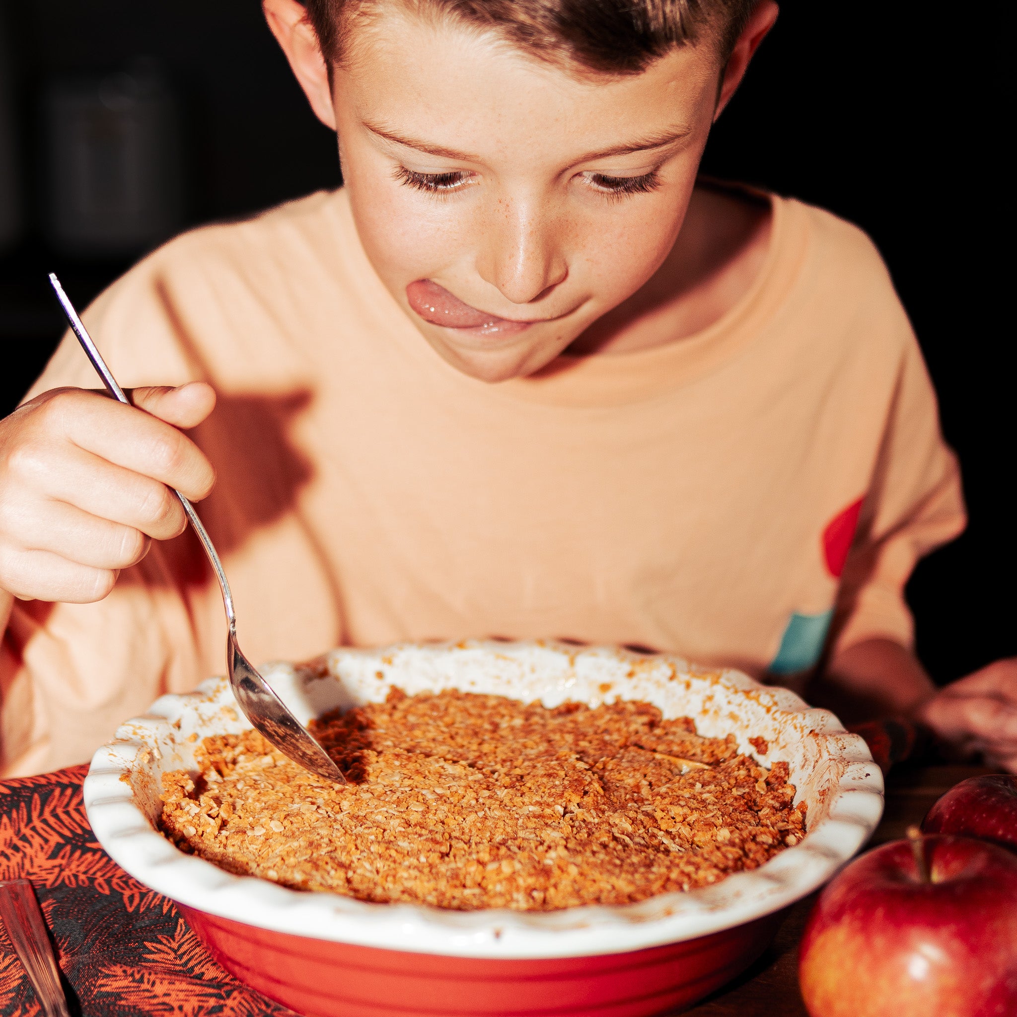 Enfant prêt à déguster une croustade aux pommes croustillante préparée avec la Mini OG, protéine végétale texturée nature de Grounded. Dessert végétalien riche en protéines et sans compromis sur le goût.