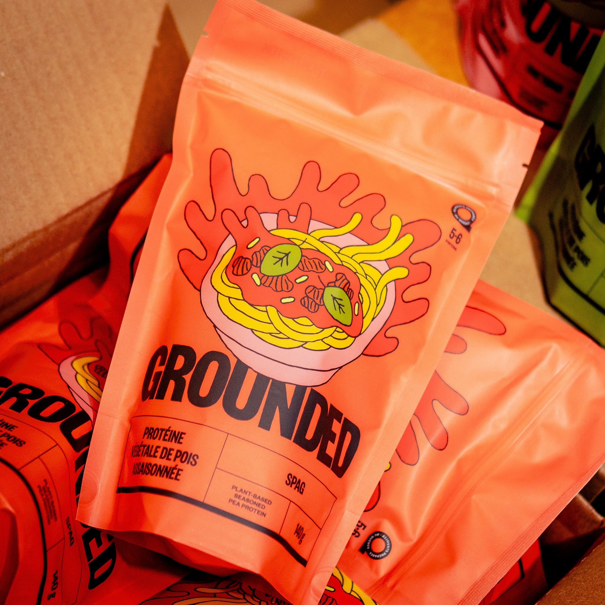 Emballage du produit SPAG de Grounded. Protéine végétale de pois assaisonnée, prête à cuisiner, dans un sachet coloré et recyclable, illustré avec un bol de spaghettis à la sauce tomate végane.