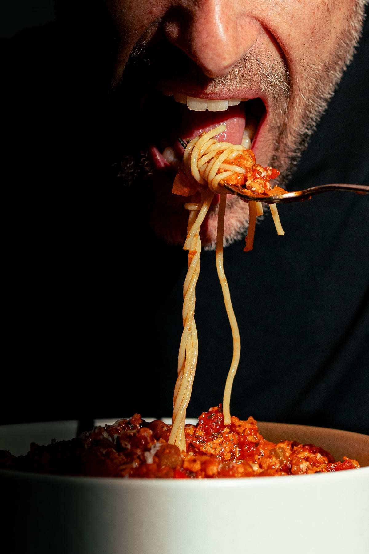 Homme savourant un plat de spaghetti à la sauce bolognaise végétale préparée avec la protéine texturée de pois Grounded – un repas réconfortant, riche en protéines, sans viande ni compromis sur le goût.”