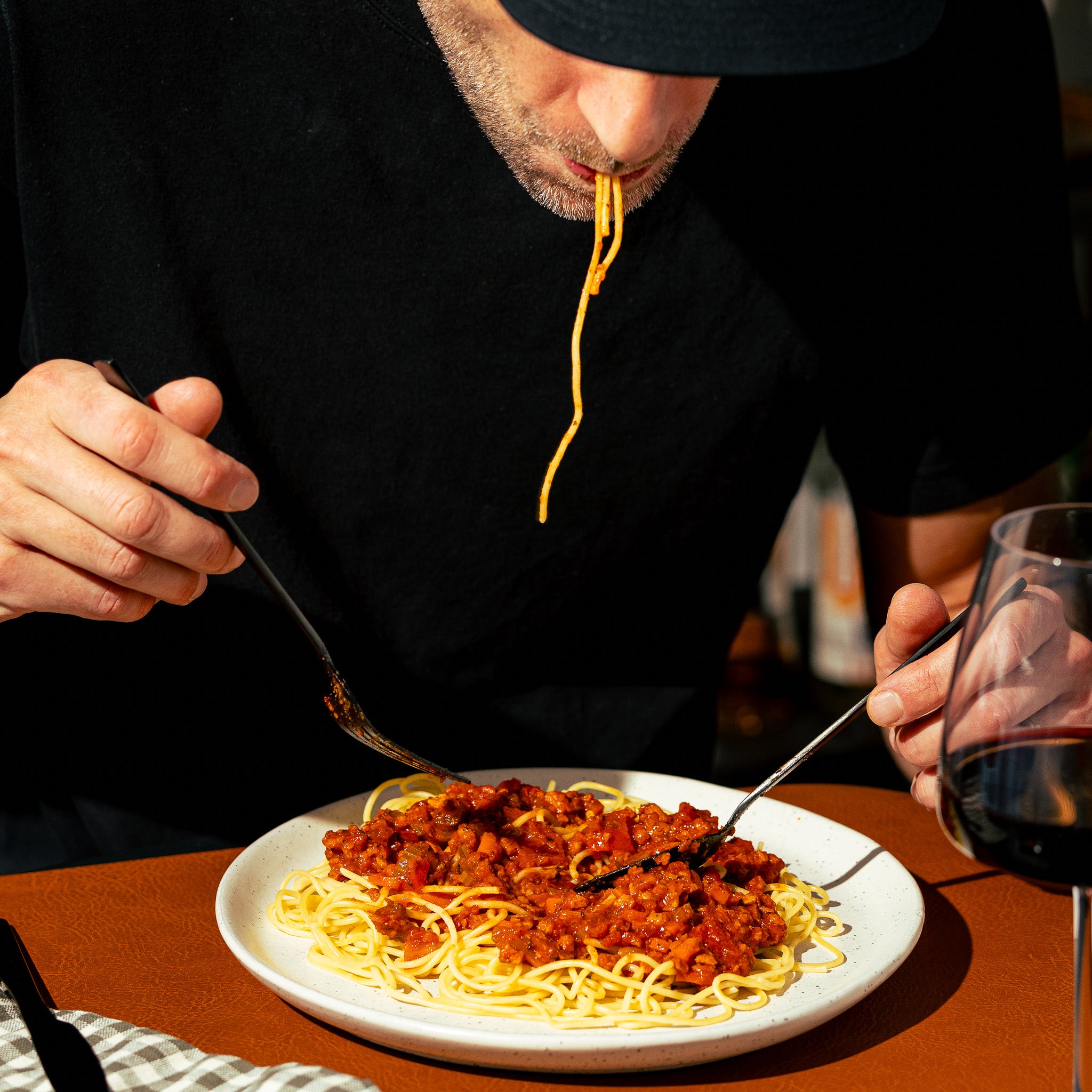 Homme dégustant un plat de spaghetti nappé de sauce bolognaise végétale Grounded, riche en protéines grâce à la protéine de pois texturée. Une alternative végane savoureuse et simple à préparer.