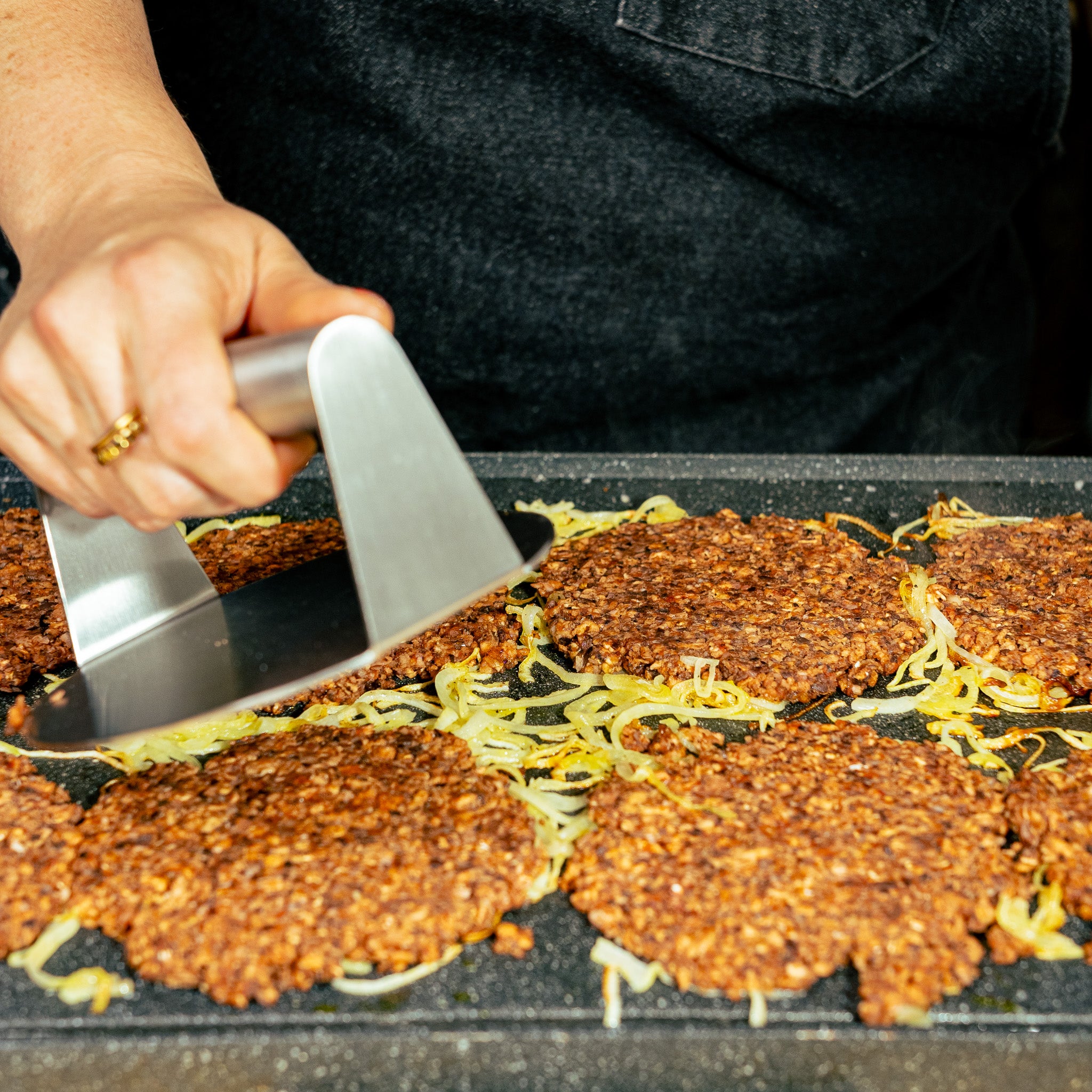 Galettes végés de PVT pour smash burgers, créées avec Loounie et grillées avec des oignons pour préparer un burger végétal riche en protéines.