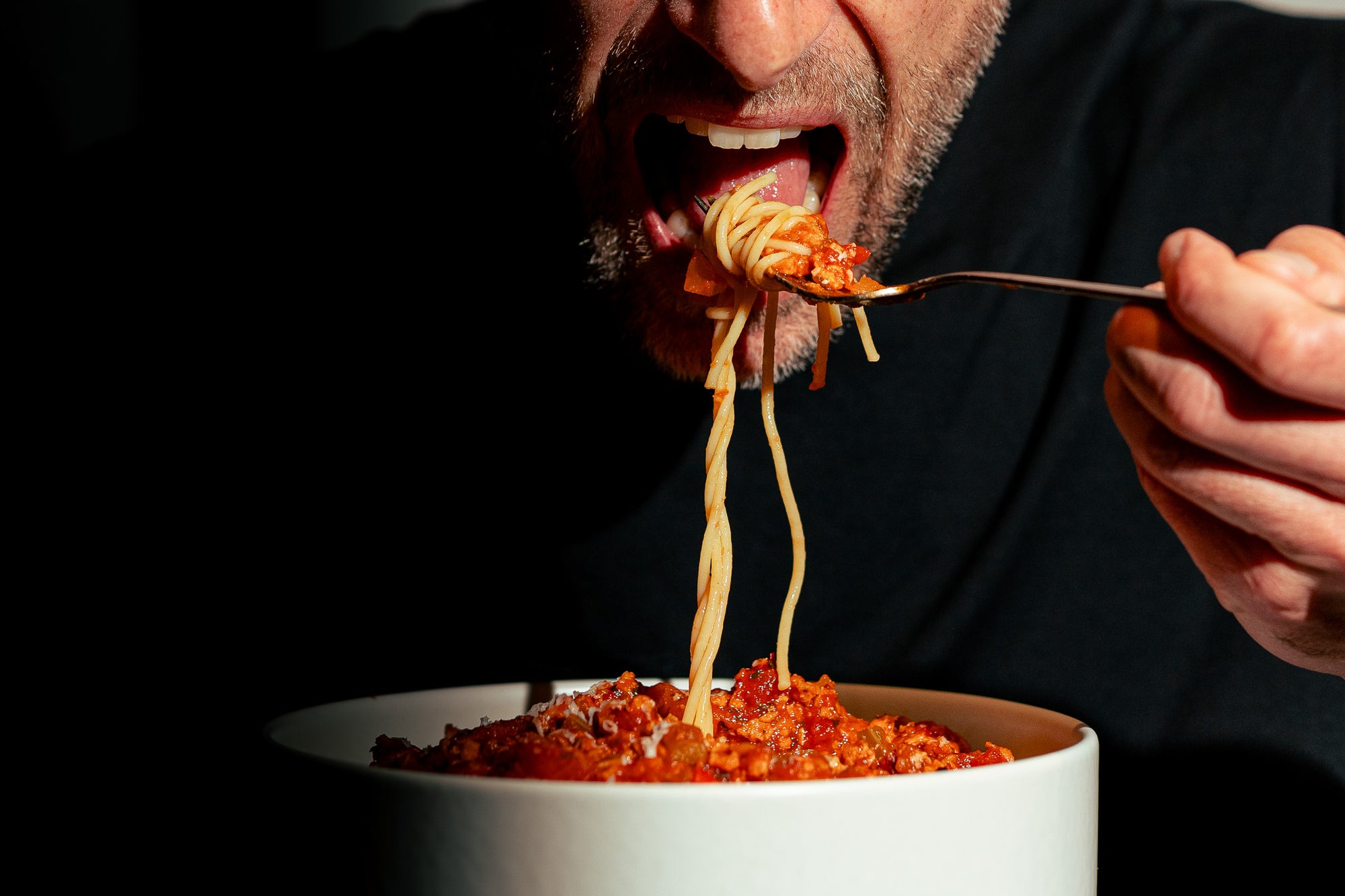 Homme savourant un plat de spaghetti à la sauce bolognaise végétale préparée avec le sachet SPAG qui contient de la protéine texturée de pois Grounded. Un repas réconfortant, riche en protéines, sans viande ni compromis sur le goût.