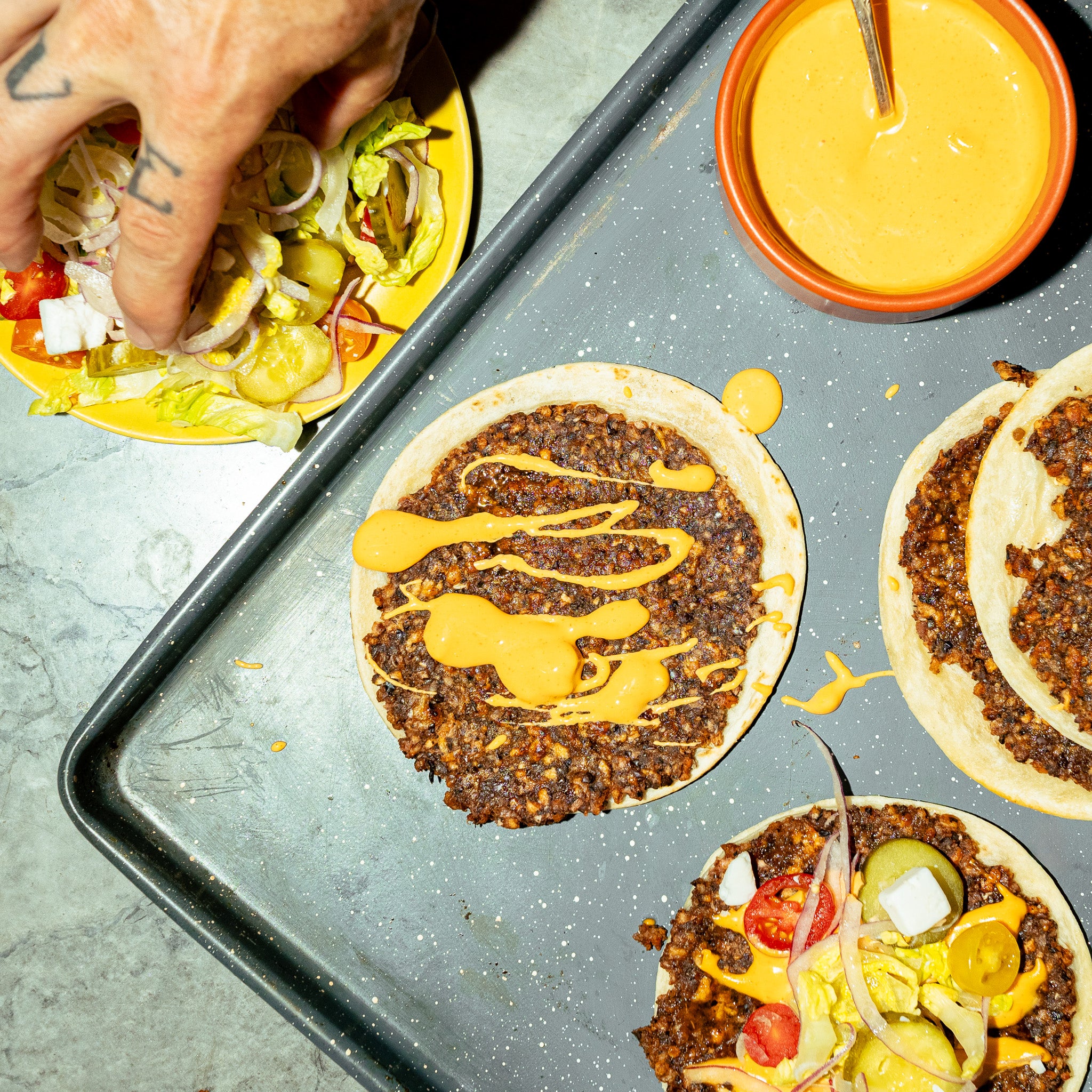 Wraps façon smash burger végé créés avec Loounie, garnis de galettes de PVT à base de protéines végétales, sauce burger, laitue, cornichons et oignons rouges.